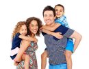 Portrait of playful young parents giving piggyback ride to children on white background