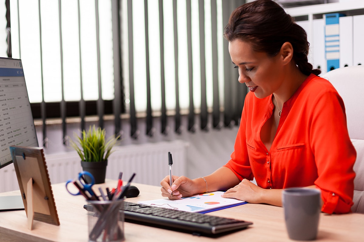 Mulher segurando uma calculadora financeira e pensando em como evitar dívidas e endividamentos